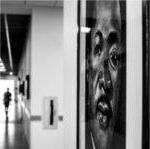 portrait of Dr. King in hallway at DCIH, person walking down hall seen from back